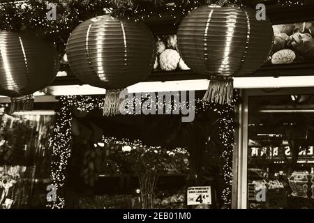 PARIS, FRANKREICH - 14. FEBRUAR 2019: Chinesische Neujahrsfeier in Paris. Asiatisches Lebensmittelgeschäft mit traditionellen Laternen dekoriert. Sepia historisches Foto Stockfoto