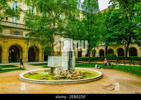 LYON, FRANKREICH, 22. JULI 2017: Die Menschen entspannen sich auf einer Bank im Park des Palastes von Saint Pierre in Lyon, Frankreich Stockfoto