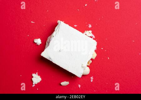 Stück Italienischer Nougat auf rotem Hintergrund. Draufsicht Stockfoto