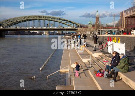 Rheinflut am 4th. Februar. 2021, Menschen auf der teilweise überfluteten Treppe am Rheinboulevard in Deutz, Blick auf die Hohenzollernbrücke, Colo Stockfoto