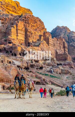 PETRA, JORDANIEN, 2. JANUAR 2019: beduinen reiten auf einem Esel vor dem Urnengrab in petra, Jordanien Stockfoto