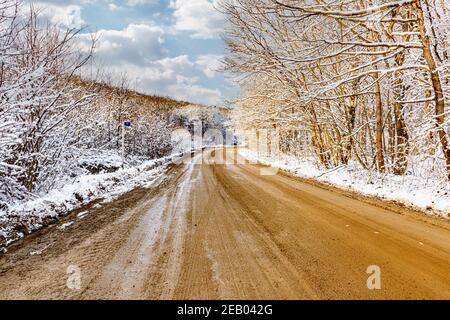 Winter Schotterstraße durch den Wald in den Bergen Stockfoto