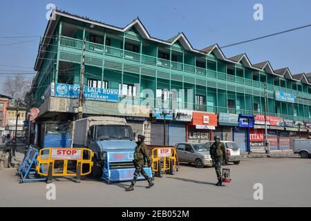 Srinagar, Indien. Februar 2021, 11th. Paramilitärische Truppen patrouillieren während der Stilllegung durch einen geschlossenen Markt.IN Kaschmir wird ein Shutdown beobachtet, um den 37th. Todestag des Gründers der Jammu and Kashmir Liberation Front (JKLF), Mohammad Maqbool Bhat, zu begehen, der an diesem Tag im Tihar-Gefängnis in Neu Delhi im Jahr 1984 gehängt wurde. Kredit: SOPA Images Limited/Alamy Live Nachrichten Stockfoto