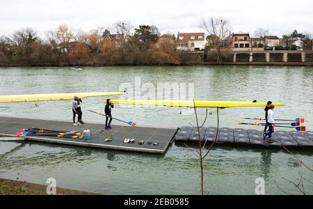 ILE-DE-FRANCE, FRANKREICH - 26. JANUAR 2019: Ausbildung von Juniorrudern am Fluss Marne. Boys tragen und bekommen das Boot im Wasser. Stockfoto