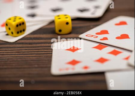 Karten spielen und Würfel auf einem Holztisch. Nahaufnahme, selektiver Fokus. Stockfoto