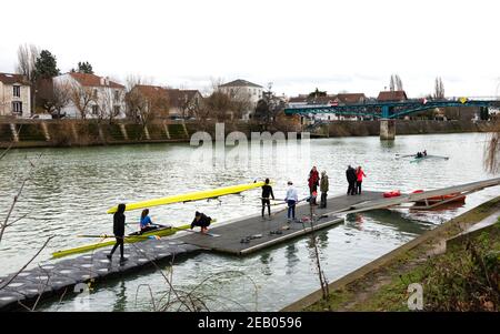 ILE-DE-FRANCE, FRANKREICH - 26. JANUAR 2019: Ausbildung von Juniorrudern am Fluss Marne. Boys tragen und bekommen das Boot im Wasser. Stockfoto