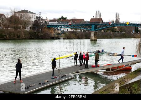 ILE-DE-FRANCE, FRANKREICH - 26. JANUAR 2019: Ausbildung von Juniorrudern am Fluss Marne. Boys tragen und bekommen das Boot im Wasser. Stockfoto