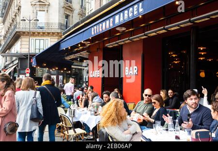 PARIS, FRANKREICH - 6. APRIL 2019: Pariser Stadtszene. Im Frühling sitzen die Leute auf der Terrasse des Cafés Etienne Marcel in der Straße Montmartre. Cafe in Paris ist imp Stockfoto