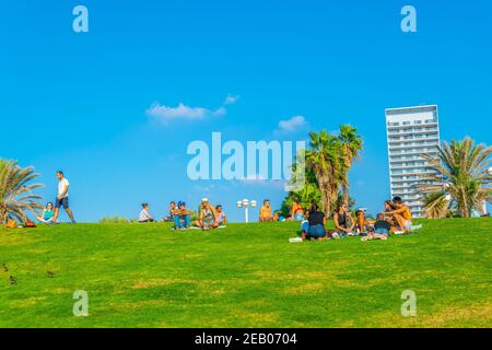 TEL AVIV, ISRAEL, 10. SEPTEMBER 2018: Menschen sitzen auf einer Wiese in Strandnähe in Tel Aviv, Israel Stockfoto