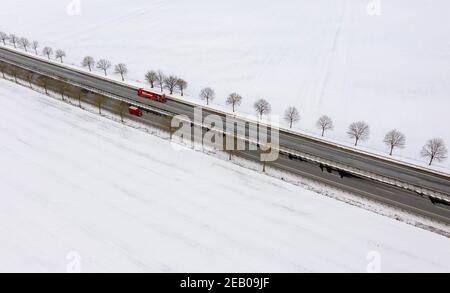 11. Februar 2021, Schleswig-Holstein, Bornhöved: Autos fahren auf der Autobahn 21, die durch eine völlig schneebedeckte Landschaft führt. Foto: Axel Heimken/dpa Stockfoto