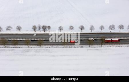 11. Februar 2021, Schleswig-Holstein, Bornhöved: Autos fahren auf der Autobahn 21, die durch eine völlig schneebedeckte Landschaft führt. Foto: Axel Heimken/dpa Stockfoto