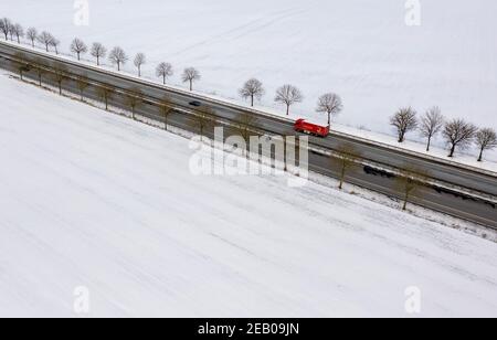 11. Februar 2021, Schleswig-Holstein, Bornhöved: Autos fahren auf der Autobahn 21, die durch eine völlig schneebedeckte Landschaft führt. Foto: Axel Heimken/dpa Stockfoto