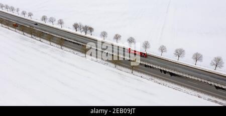 11. Februar 2021, Schleswig-Holstein, Bornhöved: Autos fahren auf der Autobahn 21, die durch eine völlig schneebedeckte Landschaft führt. Foto: Axel Heimken/dpa Stockfoto