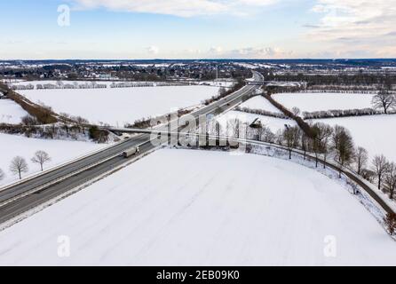 11. Februar 2021, Schleswig-Holstein, Bornhöved: Autos fahren auf der Autobahn 21, die durch eine völlig schneebedeckte Landschaft führt. Foto: Axel Heimken/dpa Stockfoto