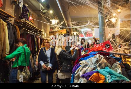 Die Leute wählen und kaufen Kleidung in Kilo Store, Vintage-Bekleidungsgeschäft verkauft Kleidung nach Gewicht in Marais Viertel, dekoriert für Halloween. Paris Frankreich Stockfoto