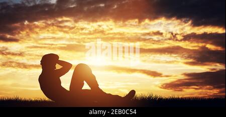 Der Mensch knirscht im Freien bei Sonnenuntergang. Bodybuilding. Training und Training. Stockfoto