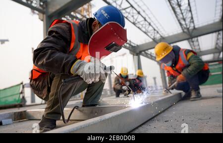 Peking, China. Februar 2021, 11th. Arbeiter führen Schweißarbeiten auf einer Baustelle am Bahnhof Fengtai im Bezirk Fengtai in Peking, der Hauptstadt Chinas, durch, 11. Februar 2021. Menschen aus verschiedenen Sektoren bleiben am Vorabend des chinesischen Neujahrsfestes, dem Frühlingsfest, das auf den 12. Februar fällt, bei ihren Beiträgen. Quelle: Wang Yuguo/Xinhua/Alamy Live News Stockfoto