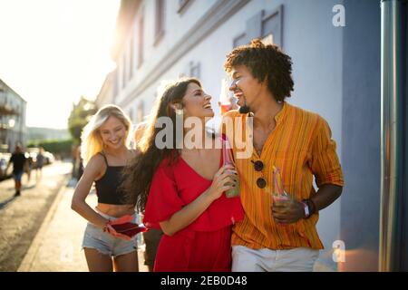 Glückliches Paar, Freunde, die zusammen Spaß haben und in der Stadt trinken Stockfoto