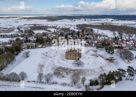 Das Bild vom Februar 10th zeigt die Schlittenfahrten von Castle Rising in Norfolk, das an das Sandringham Estate grenzt, das jetzt von dem jüngsten Schneefall bedeckt ist.Castle Rising ist eine zerstörte mittelalterliche Festung im Dorf Castle Rising, Norfolk.Es wurde bald nach 1138 von William d'Aubigny II. Erbaut Das Met Office hat eine gelbe Warnung für Schnee im Südosten und Osten Englands sowie für Schnee und Eis im Norden Englands angebracht. Heute wird es wieder einen kalten Tag geben, aber es wird für viele weniger windig sein, und der Westen wird einige gute Sonneneinstrahlungen haben. Es wird erwartet, dass die Schneeschauer andauern Stockfoto
