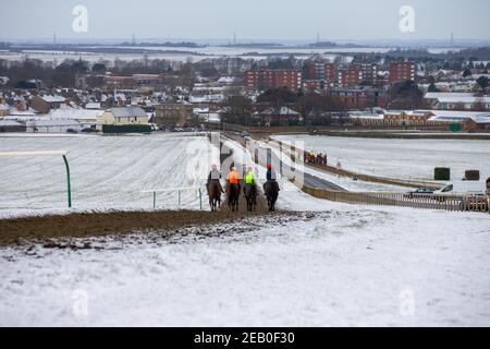 Bild vom 9th. Februar zeigt Jockeys und Rennpferde beim Training auf der Allwetterstrecke in Newmarket, Suffolk, am Dienstagmorgen bei eisigen Temperaturen und umliegender Schneedecke.Mehr Schnee und Regen werden für die nächsten 48 Stunden prognostiziert, da Sturm Darcy weiterhin schlechtes Wetter in Teile des Landes bringt. Stockfoto