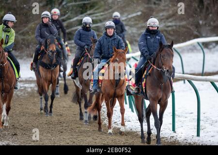 Bild vom 9th. Februar zeigt Jockeys und Rennpferde beim Training auf der Allwetterstrecke in Newmarket, Suffolk, am Dienstagmorgen bei eisigen Temperaturen und umliegender Schneedecke.Mehr Schnee und Regen werden für die nächsten 48 Stunden prognostiziert, da Sturm Darcy weiterhin schlechtes Wetter in Teile des Landes bringt. Stockfoto