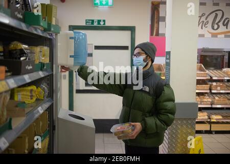 Sheffield, Großbritannien, 14th. Januar 2021: Ein Morrisons-Kunde desinfiziert seine Hände aufgrund der Coronavirus-Maßnahmen im Laden. Stockfoto