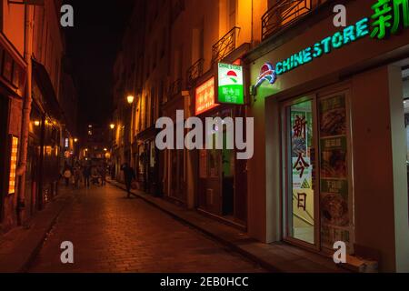 PARIS, FRANKREICH - 19. OKTOBER 2019: Städtische Abendszene in einem der ältesten asiatischen Viertel von Paris (3rd Bezirk). Leute kaufen in den lokalen Geschäften ein; essen im po Stockfoto