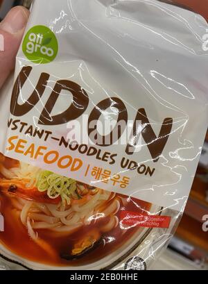 Viersen, Deutschland - Februar 9. 2021: Nahaufnahme von japanischen udon Instant Seafood Nudeln vor dem Regal des deutschen Supermarkts Stockfoto