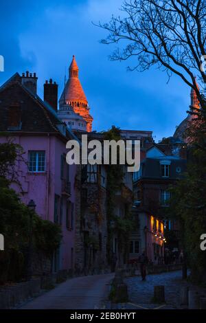 PARIS, FRANKREICH - 16. NOVEMBER 2019: Abendansicht Montmartre Viertel mit 'La Maison Rose' (Pink House) Restaurant und Basilika des Heiligen Herzens (Sacre C Stockfoto