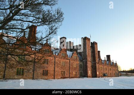 Historisches Knole House, ein Tudor Wahrzeichen in Sevenoaks, Kent, im Februar 2021 während eines "Bestie aus dem Osten" an einem knackigen Tag mit Schnee. Sonnenstrahlen an der Fassade Stockfoto