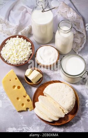 Verschiedene frische Milchprodukte, Milch, Sauerrahm, Quark, Joghurt und Butter auf einer leichten Steinplatte. Stockfoto