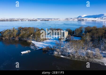 Kinross, Schottland, Großbritannien. Aus der Vogelperspektive eines schneebedeckten Lochleven Castle auf einer kleinen Insel auf Loch Leven, Kinross-Shire. Stockfoto
