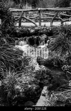 Schöne Brücke über den Bach in der Nähe von Daumesnil See in Vincennes Wald von Paris, Frankreich. Schwarz weiß historisches Foto Stockfoto