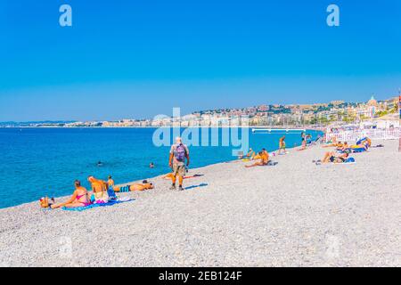 NIZZA, FRANKREICH, 11. JUNI 2017: Die Menschen genießen den Sommer an einem Strand in Nizza, Frankreich Stockfoto