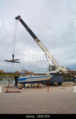 Ein hydraulischer mobiler, hängend getragener Bootsheber oder Hebezeug mit einer Schlinge. Gelegen in einem Jachthafen außerhalb der Saison in Norditalien Stockfoto