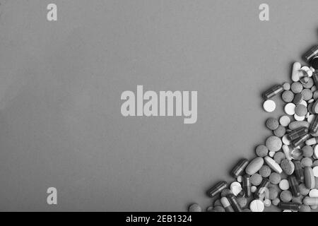 Rahmen aus runden Pillen und Kapseln auf einer Seite gelegt. Medizin und Behandlungskonzept. Satz von bunten Pillen auf grünem Hintergrund verstreut, kopieren Raum. Medikamente in der unteren Ecke platziert. Stockfoto