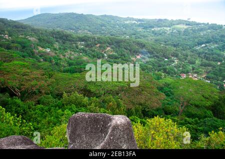 Panorama über die Insel La Digue auf den Seychellen mit typischem Granit Rock im Vordergrund und die lokalen Dörfer im Hintergrund Tal Stockfoto