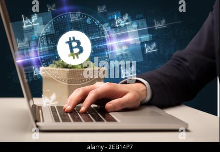 Business Hand arbeiten an der Börse mit Bitcoin-Symbole kommen Aus dem Laptop-Bildschirm Stockfoto