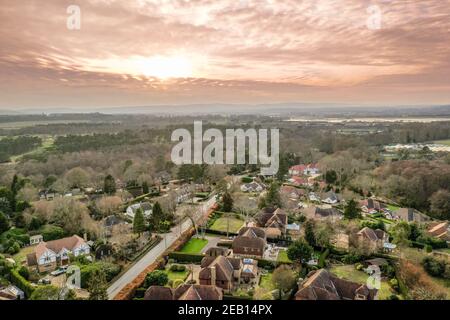 Luftdrohnenaufnahme eines ländlichen Dorfes in West Sussex, England. Große Wohnanlage mit Gärten unter den South Downs im Winter. Stockfoto