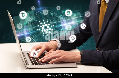 Business Hand arbeiten an der Börse mit cardano Symbole kommen Aus dem Laptop-Bildschirm Stockfoto