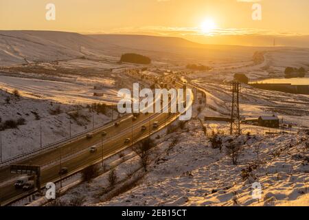 Sonnenuntergang über der Autobahn M62 im Winter, Blick nach Westen von der Scammonden Brücke in Richtung des Gipfels, der 372M über dem Meeresspiegel liegt. Englands höchste m'way Stockfoto