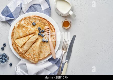 Crepes, dünne Pfannkuchen oder Blini mit Beeren auf weißem Teller. Draufsicht. Pfannkuchen Woche. Fasching. Leerzeichen für Text. Stockfoto