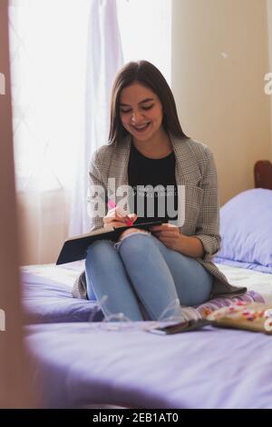 Junge Frau schreibt in ihr Tagebuch. Ihre Gedanken und Ideen. Stockfoto