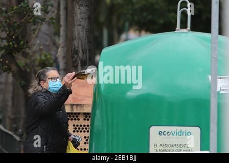 Februar 11, 2021 (Malaga) EINE Frau recycelt Glasflasche und Karton Kredit: CORDON PRESS/Alamy Live News Stockfoto