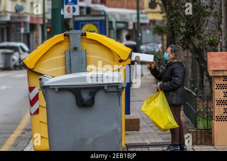 Februar 11, 2021 (Malaga) EINE Frau recycelt Glasflasche und Karton Kredit: CORDON PRESS/Alamy Live News Stockfoto
