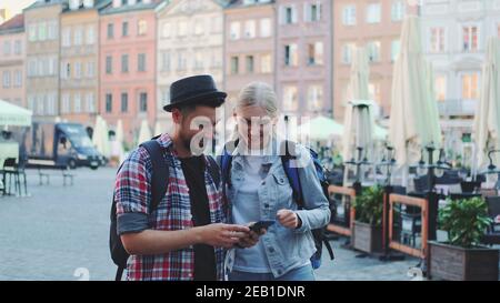 Junge Touristen mit Smartphone und bewundern schöne Umgebung. Sie gehen früh am Morgen Sightseeing. Stockfoto