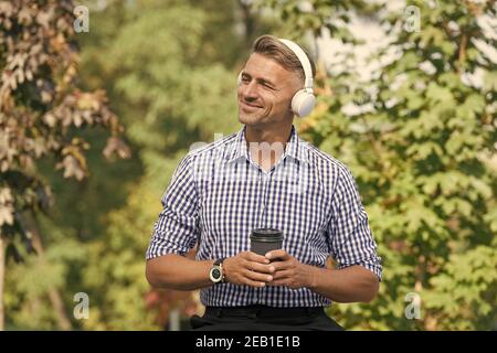 Inspiriert von der Umwelt. Vorteile für Remote-Arbeit. Kaffeepause. Belohnen Sie sich und ermutigen. Mann trinkt Kaffee hören Lieblingsmusik Künstler. Mittagszeit. Kaffee im Freien Natur Hintergrund. Stockfoto