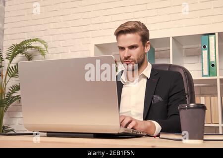Konzentrierter Broker. Wirtschaft Rezession und Erholung. Finanzexperte Mann arbeiten mit Laptop trinken Kaffee. Börsenkonzept. Finanzielle Investitionen Kryptowährung. Finanzdirektorbüro. Stockfoto