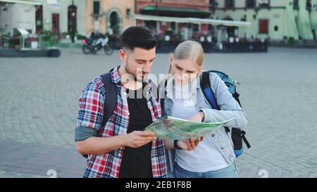 Touristen halten Karte und auf der Suche nach einem Platz auf dem Stadtplatz. Sie gehen Sightseeing. Stockfoto