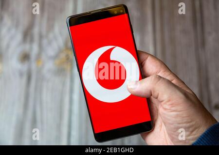 Ein Mobiltelefon oder Mobiltelefon, das von einem gehalten wird Hand mit der Vodafone App geöffnet auf dem Bildschirm Stockfoto